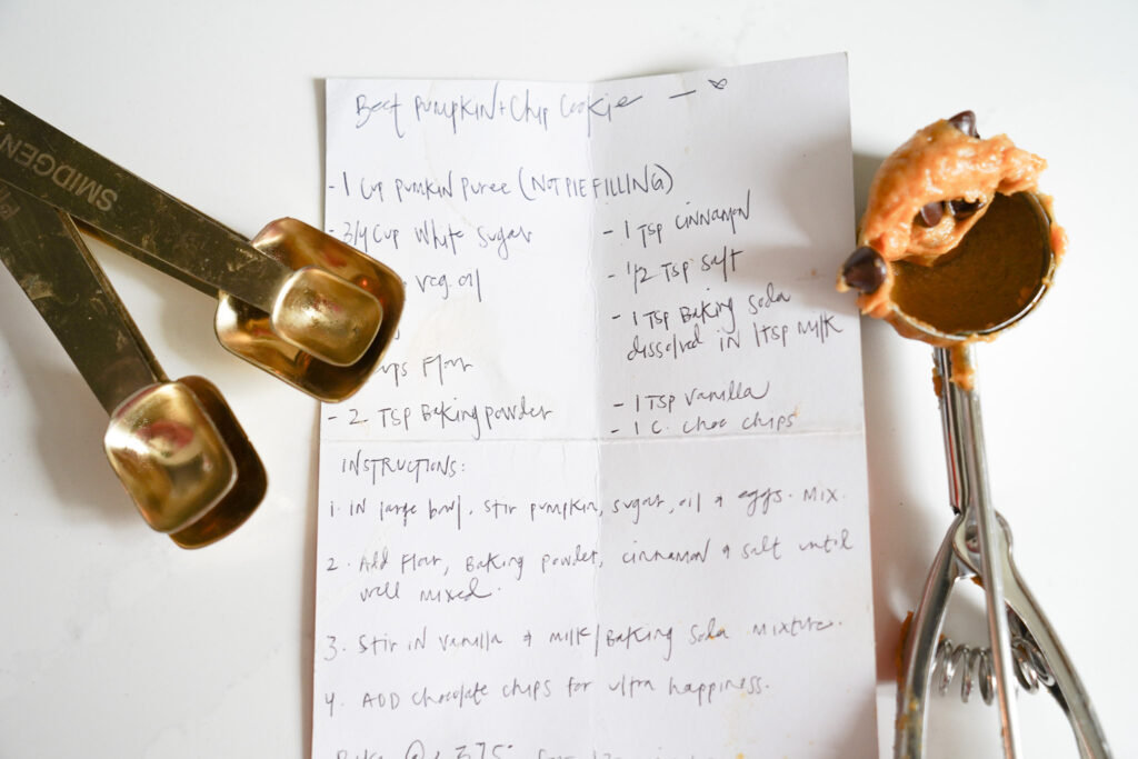 Hand written recipe card with cookie scoop and vintage measuring spoons
