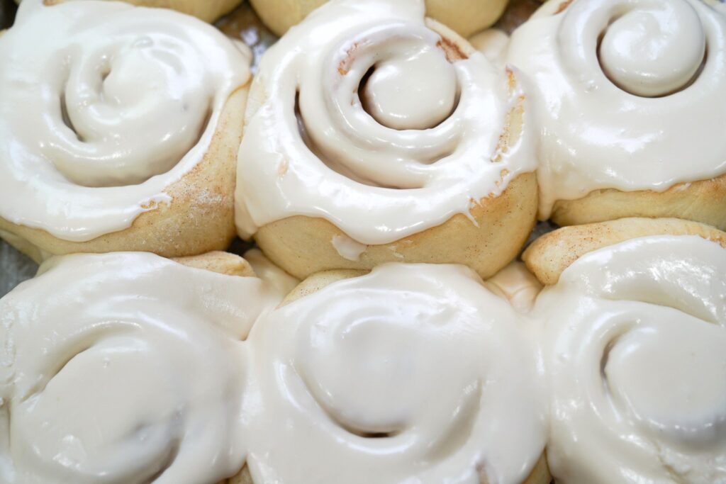 Cinnamon rolls in a bunch with frosting on them.