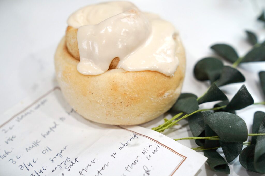  Cooked Cinnamon roll with icing and with a handwritten recipe