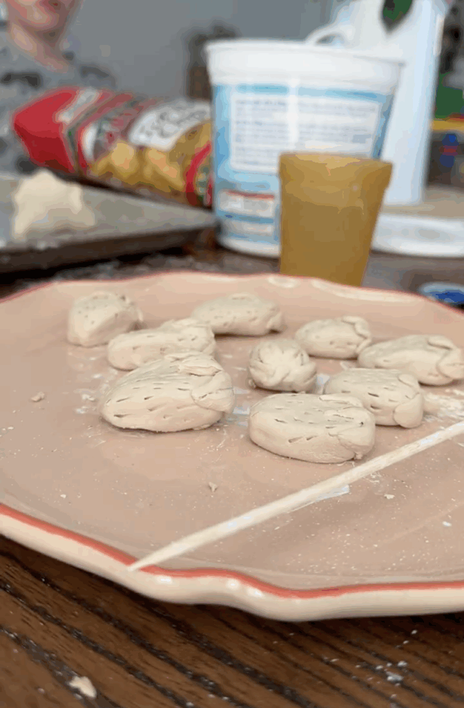 Unpainted clay strawberries with seed details drying on a plate before being added to a DIY lamp makeover.