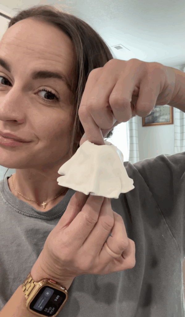 Woman holding a handmade clay ghost candlestick holder before baking.